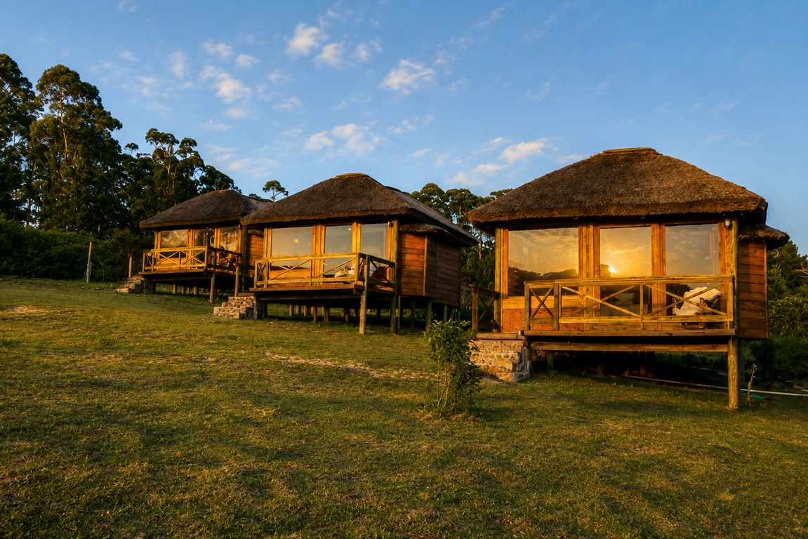 Refúgio Monte Itapeva cabins glowing at sunset on the hillside